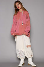 Load image into Gallery viewer, Woman wearing pink hooded knit top with exposed seams, white baggy pants with lace detailing, and white boots, ideal for winter clothes.
